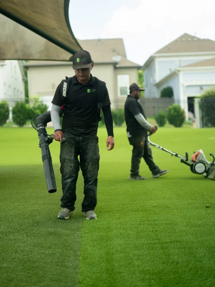 Landscaper using a leaf blower during a commercial turf installation project